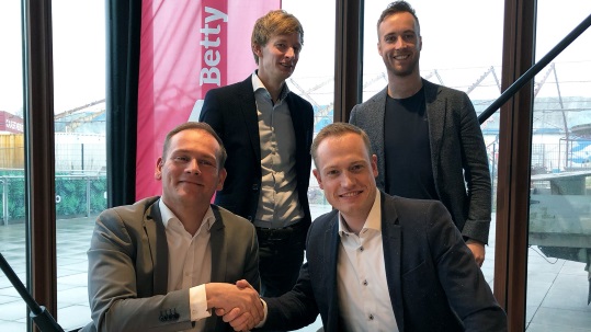 De ondertekening van de samenwerking, met vooraan Chris Obdam, CEO Betty Blocks (l), en Kay Lankheet, Managing Consultant en Founder van BlockBrains (r), en achteraan Allard Brand, Technical Lead en Founder BlockBrains (l) en Tom Oudhuis, VP of Channel Sales bij Betty Blocks. 